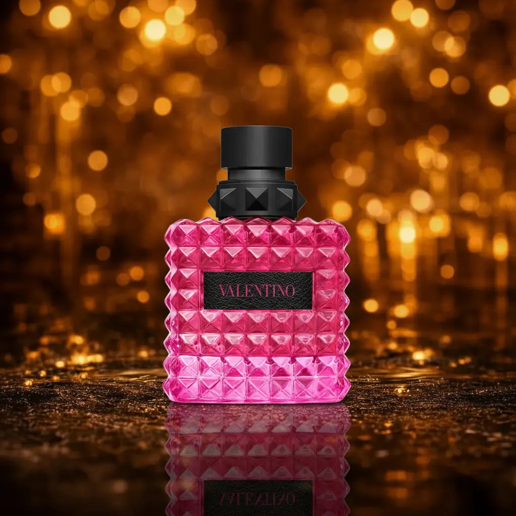 Valentino Donna Born in Roma Extradose Eau de Parfum pink og sort flakon på mørk våd overflade med blød gylden bokeh baggrund
