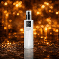 COSRX BHA Blackhead Power Liquid. Hvid flaske med klar pumpe og sort kvadratisk label. Stående på våd mørk stenoverflade. Varme amber bokeh lys i baggrunden.