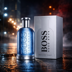 Hugo Boss Bottled Tonic Eau de Toilette parfume til mænd med blå glasflaske og sølvgrå original æske placeret på våd asfalt med bylys refleksioner og kølig tåge i natlig urban scene