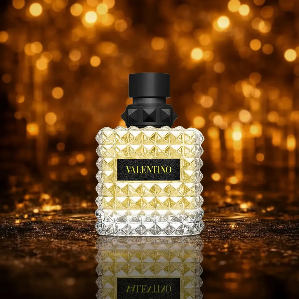 Valentino Donna Born in Roma Yellow Dream Eau de Parfum gul og sort flakon på mørk våd overflade med gylden bokeh baggrund 