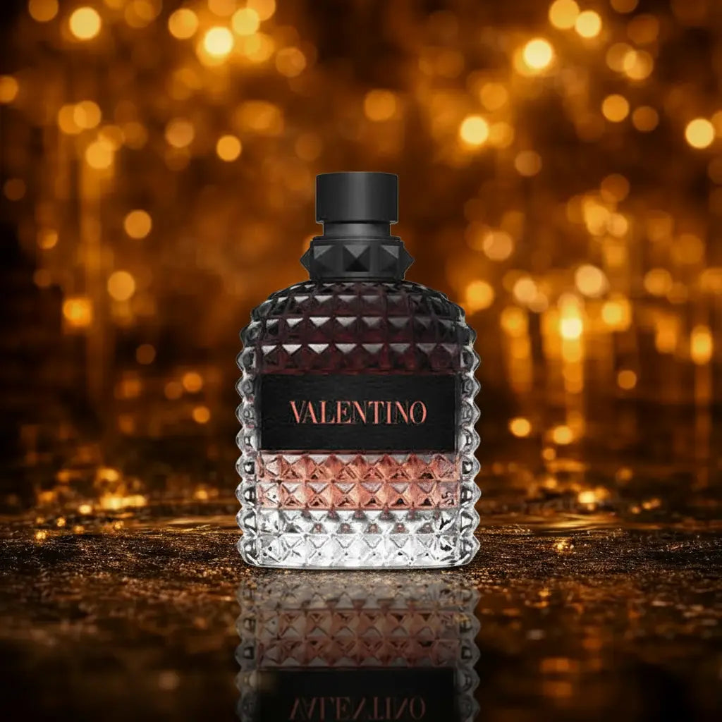 Valentino Uomo Born in Roma Coral Fantasy Eau de Toilette sort og coral gradient flakon med sort mærke og coral Valentino tekst på mørk våd overflade med gylden bokeh baggrund