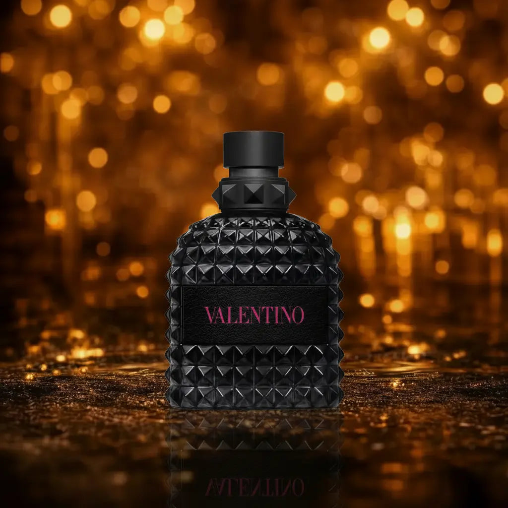 Valentino Uomo Born in Roma Extradose Eau de Parfum helt sort flakon med pink Valentino tekst på mørk våd overflade med gylden bokeh baggrund 