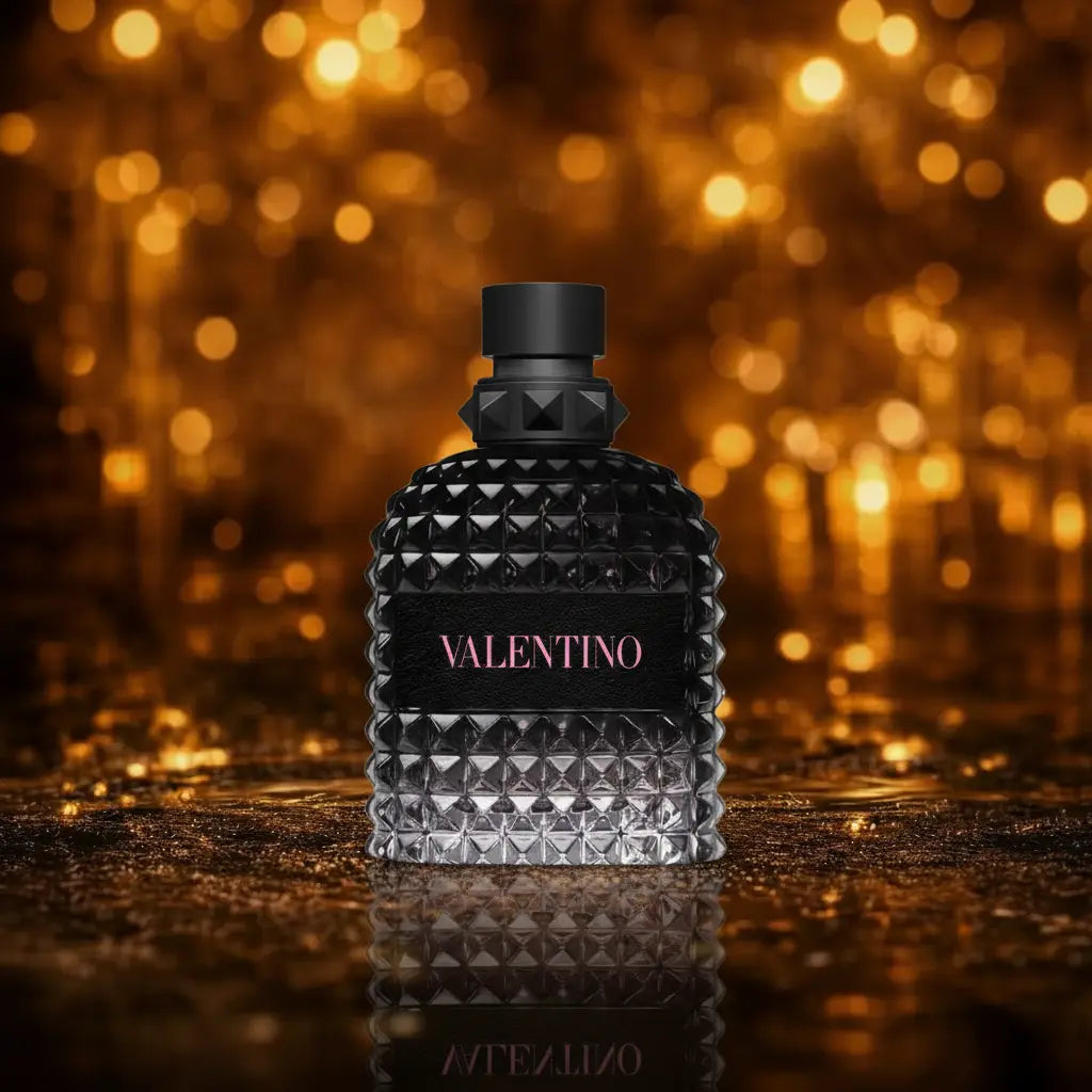 Valentino Uomo Born in Roma Eau de Toilette sort og grå flakon med pink Valentino tekst på mørk våd overflade med gylden bokeh baggrund 