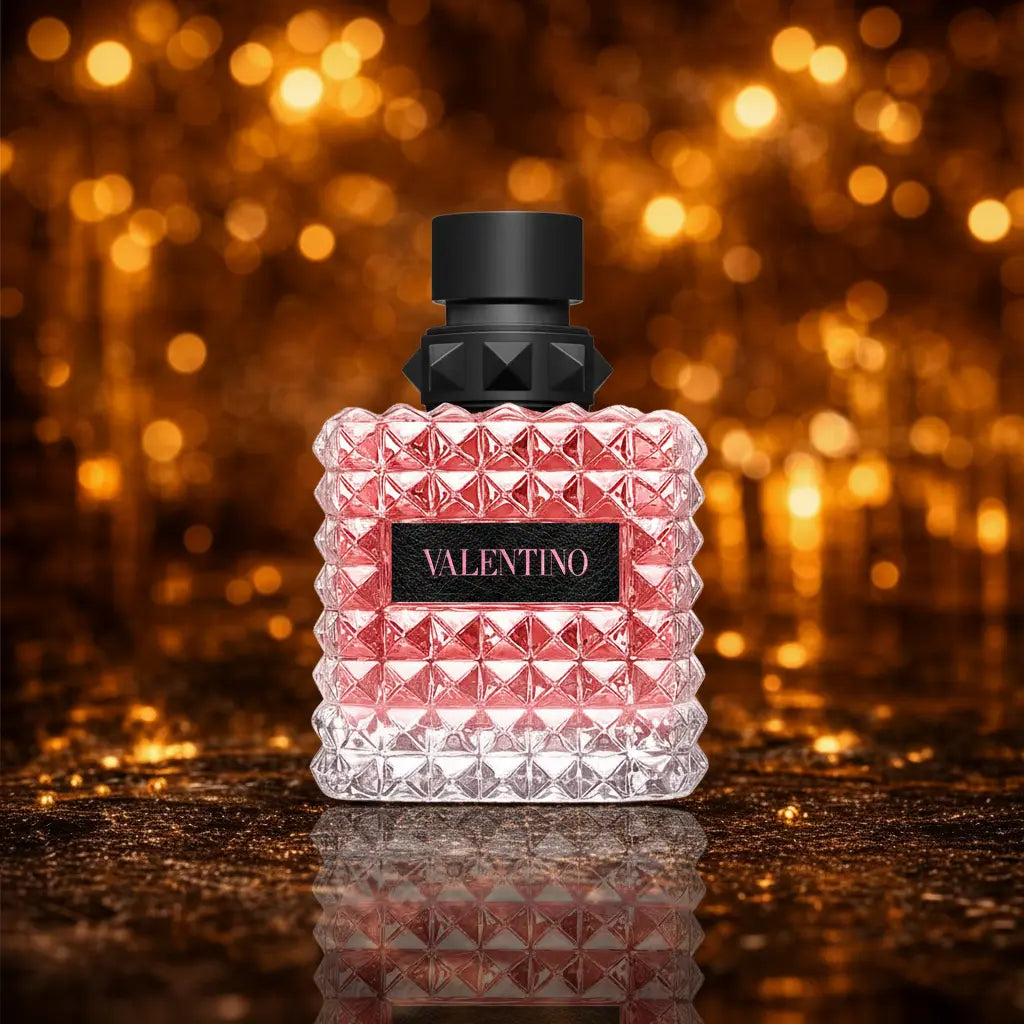 Valentino Born in Roma Donna Eau de Parfum pink facetteret krystalflacon på mørk gylden glitter overflade med varme amber bokeh-cirkler 