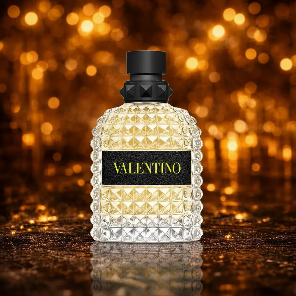 Valentino Born in Roma Yellow Dream Uomo Eau de Toilette gul og klar facetteret flakon med sort låg centreret på mørk gylden glitter overflade med varme orange og guld bokeh cirkler og tydelig spejling i overfladen nedenunder. 